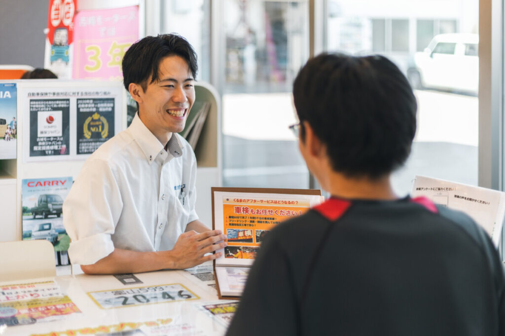 石川県白山市の古城モータース店内で説明をするスタッフとお客様の様子